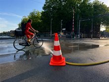 Brug wordt afgekoeld op een hete dag en iemand fiets door het water heen